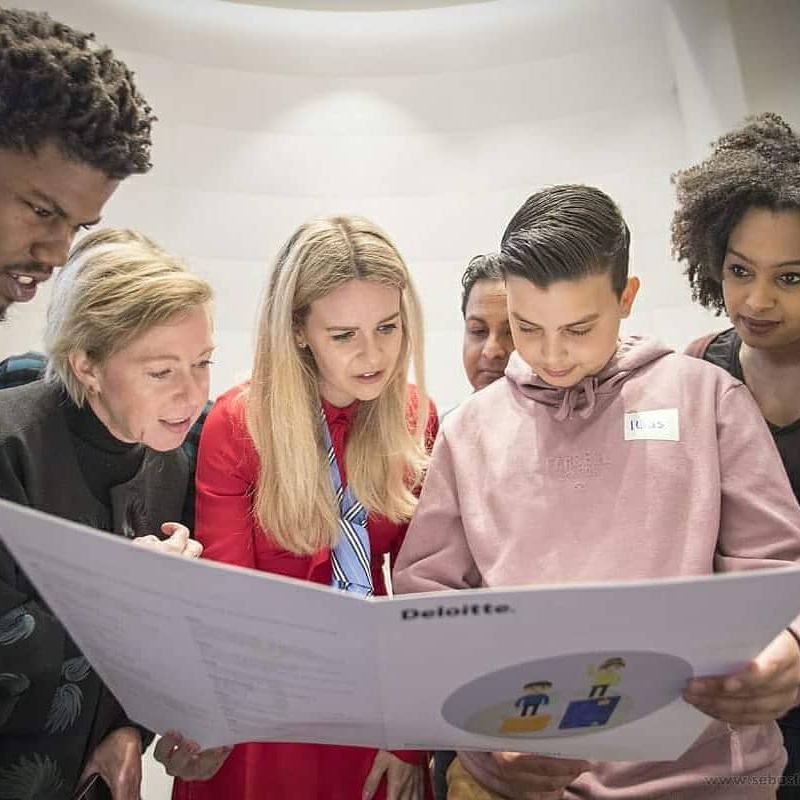 Participants poring over a printed document in a 2018 working session on education and policy