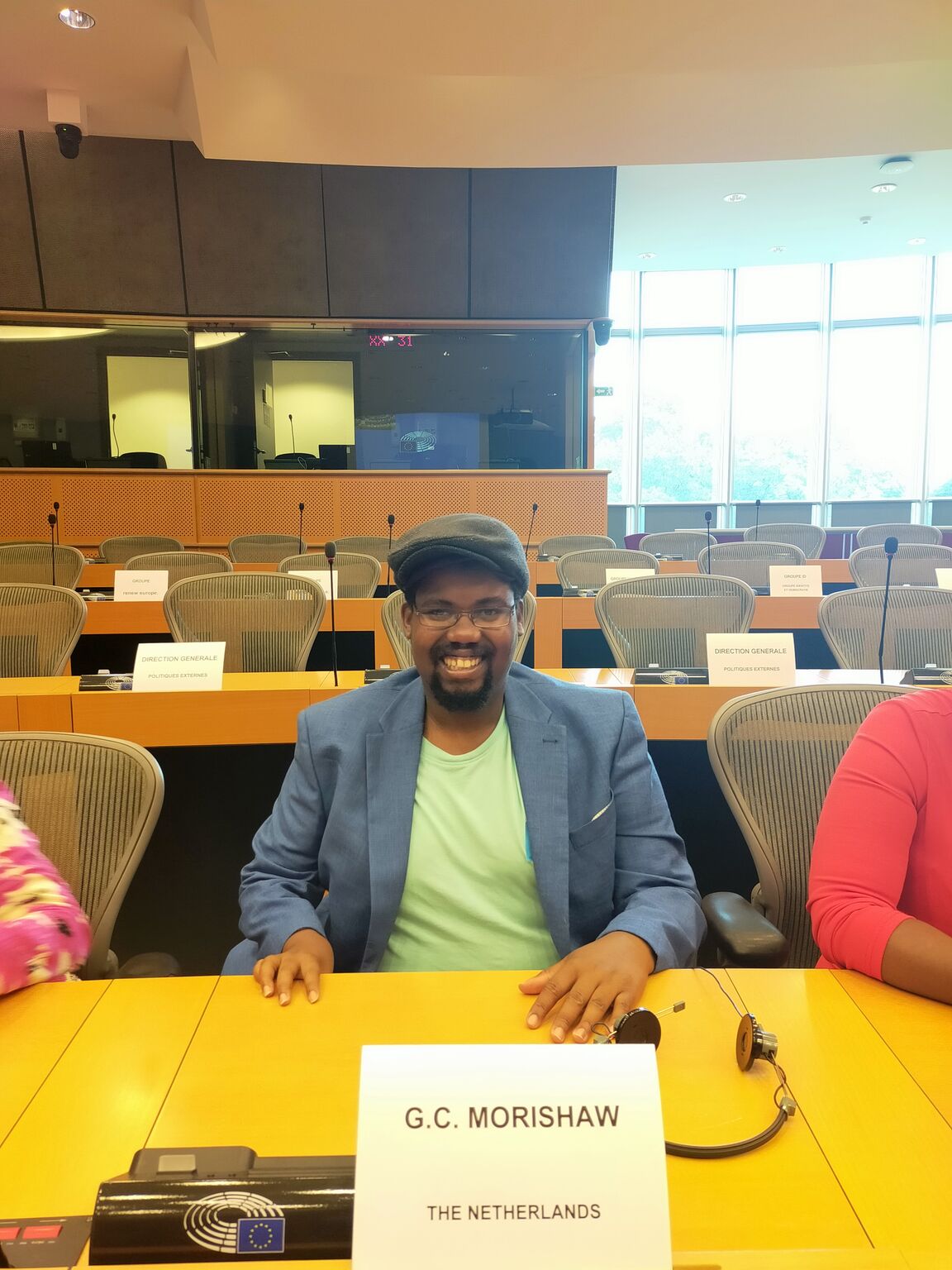Gilberto Morishaw seated at a European Parliament meeting table, nameplate reading G.C. Morishaw, The Netherlands