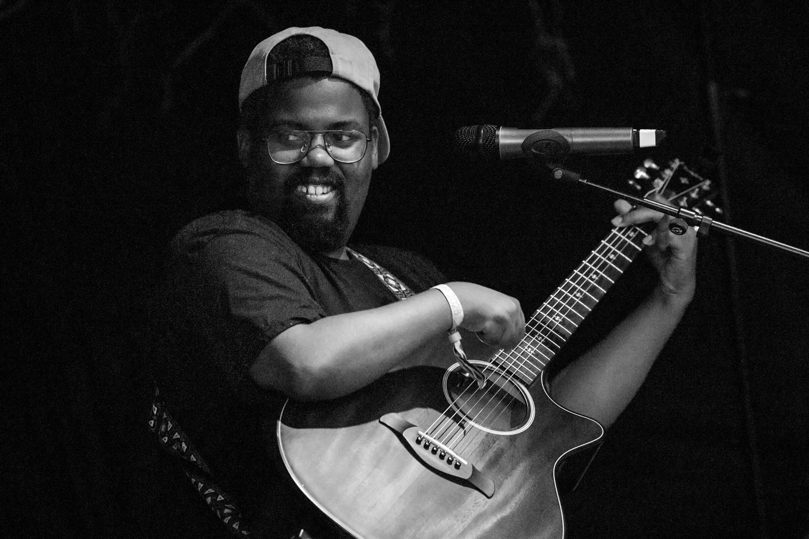 Gilberto Morishaw playing acoustic guitar and singing at DWeb Camp 2026
